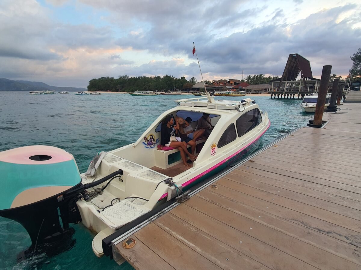 Princess speedboat docked at the wooden pier on Gili Meno with turquoise waters in the background