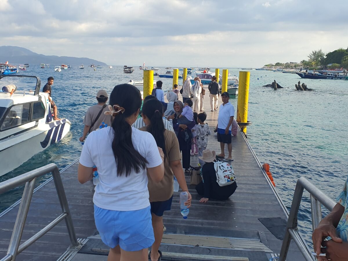 Passengers walking along the dock at Gili Trawangan port to board a speedboat